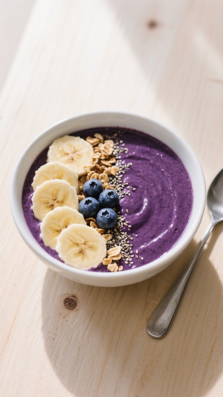 Tasty top view: Overhead shot of a smoothie bowl version—ultra-thick blueberry smoothie (dark purp